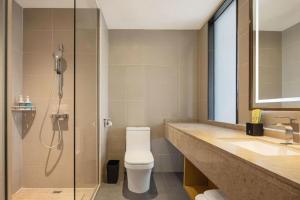 a bathroom with a shower and a toilet and a sink at City Comfort Inn Maoming Xinyi Donghuicheng in Xinyi +180 photos