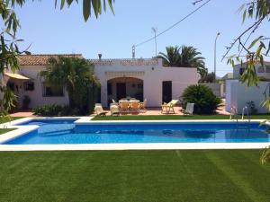 una casa con piscina frente a un patio en Chalet La Marina, en Denia