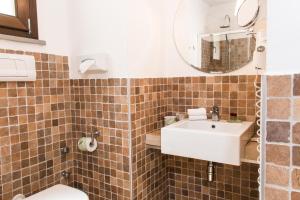 bagno con lavandino, servizi igienici e specchio di Belmonte Hotel, Dependance Alba Palace Hotel a Favara