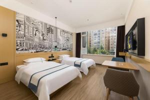 a hotel room with two beds and a tv at City Comfort Inn Chengdu Transportation Technical College Traditional Chinese Medicine in Chengdu