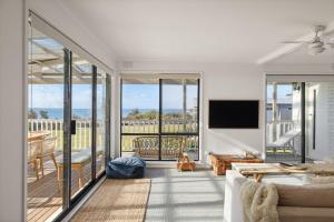 a living room with a couch and a balcony at Casa Blanca Ventnor Beach in Ventnor