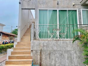 a staircase leading to a house with a table on a balcony at Check-in Resort Koh Larn in Ko Larn