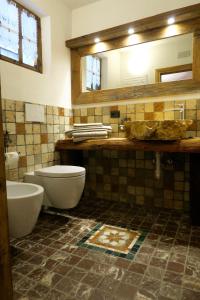 bagno con servizi igienici, lavandino e specchio di Agriturismo Baita De L'ALL a Valdidentro