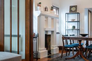 a dining room with a table and a fireplace at Deco Days - Prahran in Melbourne