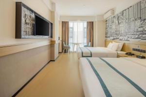 une chambre d'hôtel avec deux lits et une télévision à écran plat dans l'établissement City Comfort Inn Dandong Railway Station Yalu River Scenic Area, à Dandong