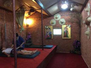 twee mensen zitten op matten in een kamer bij Himawari Restaurant & Cottage in Ban Nong Hin