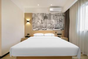 a bedroom with a large white bed and a drawing on the wall at City Comfort Inn Wuhan Changfeng Avenue 3rd Hanxi Road in Wuhan