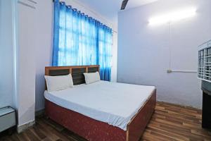 Hotel O Jyoti Palace في ميروت: غرفة نوم بسرير وستارة زرقاء +22 صورة