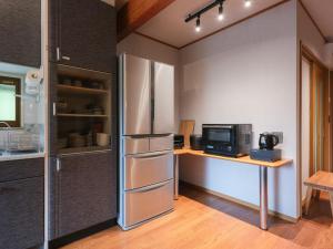 a kitchen with a refrigerator and a desk with a microwave at Enza - Vacation STAY 69573v in Katori