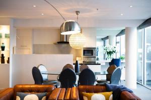 a living room with a table and leather chairs at Taimana Queenstown in Queenstown +38 photos