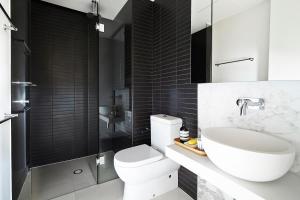 a bathroom with a sink, toilet and bathtub at Boutique Abode 316 in Melbourne