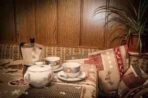 a table with three cups and a tea set on it at Casa Serac´ in La Valle