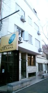 un edificio con una señal delante de él en Hotel Milena en Mendoza