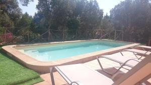una piscina en un patio con 2 sillas y una mesa en Son Vent, en Valldemossa
