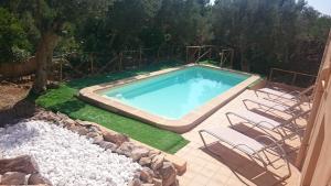 una piscina con sillas blancas junto a un patio en Son Vent, en Valldemossa