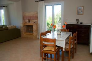 a dining room with a table and chairs and a fireplace at Garden Villas in Koroni