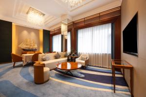a living room with a couch and a tv at Ocean Hotel Guangzhou in Guangzhou