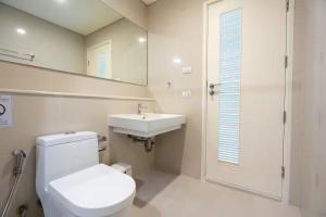 ein Badezimmer mit Toilette, Waschbecken und Spiegel in der Unterkunft Luxury Condo with Swimming Pool, Fast Wifi, 711, Big Room, Jacuzzi in Bangkok + 7 Fotos