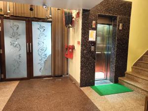 a hallway with doors and a green mat in a building at Hotel AMAN PALACE in Prayagraj +9 photos