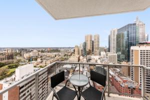 a balcony with chairs and a view of the city at Oaks Melbourne on Lonsdale Suites in Melbourne