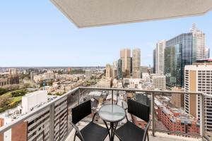 墨尔本Oaks Melbourne on Lonsdale Suites的市景阳台配有椅子