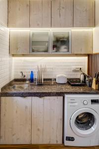 a kitchen with a sink and a washing machine at Pebble Studio Bandra W The Bombay Home Company - Eco in Mumbai
