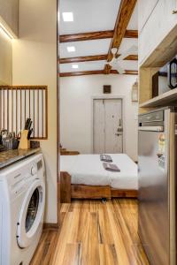a room with a bed and a washer and dryer at Pebble Studio Bandra W The Bombay Home Company - Eco in Mumbai
