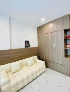a living room with a white couch in a room at Shi House - Studios Building GH6 Near Vincom& Park in Long Bình