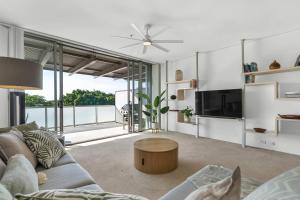 a living room with a couch and a table at Cairns Coastal Charmer - Your Waterfront Sanctuary in Cairns