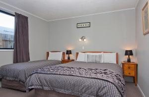a bedroom with two beds and a window at Coronation Park Holiday Park in Ashburton
