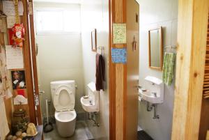 a bathroom with two toilets and two sinks at Minshuku Agaihama in Yonabaru +39 photos