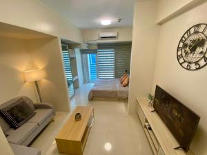 a living room with a couch and a bed and a clock at Seravé Home in Sampong