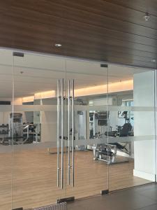 a gym with glass walls and a gym with exercise equipment at Seravé Home in Sampong
