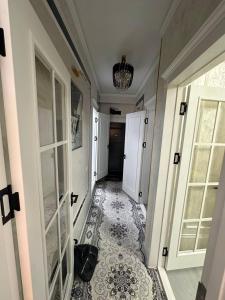 een hal met een tegelvloer en witte deuren bij Luxanda Plaza in Samarkand