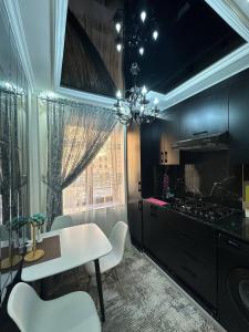 een keuken met een tafel en stoelen en een fornuis bij Luxanda Plaza in Samarkand