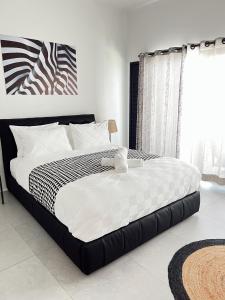 une chambre avec un lit avec une couette noire et blanche dans l'établissement NEW Coral Bay 2Bdrm Apartment - Wailoaloa, Palm Beach Estate, à Nadi 34 autres photos