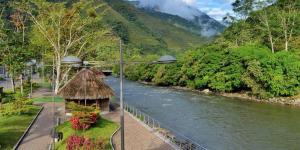 a view of a river with a hut next to a mountain at Hotel GM Double bed Zamora chinchipe in Zamora