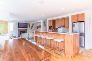 a kitchen with wooden cabinets and a wooden table at Wajima Niseko in Kutchan +6 photos