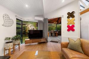 a living room with a couch and a television at Arrowtown Luxury Escape Hot Tub Central Heating in Arrowtown