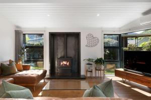 a living room with a couch and a fireplace at Arrowtown Luxury Escape Hot Tub Central Heating in Arrowtown +32 photos