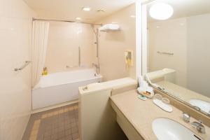 ein Badezimmer mit einem Waschbecken, einer Badewanne und einer Badewanne in der Unterkunft Hotel Nikko Tachikawa Tokyo in Tachikawa