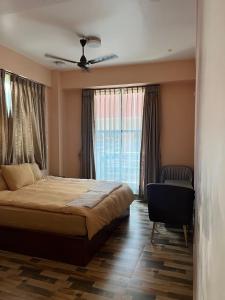 une chambre avec un lit et un ventilateur de plafond dans l'établissement Kathmandu Family Guest House, à Pātan