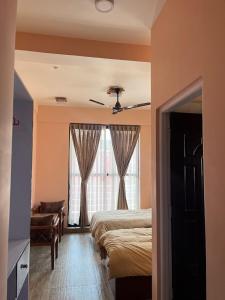 une chambre avec deux lits et une fenêtre dans l'établissement Kathmandu Family Guest House, à Pātan