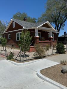 a brown house with a fence in front of it at Brick Bungalow 1 block to I80 charmingly renovated in Reno
