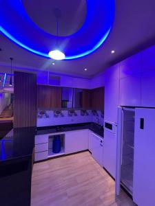 a kitchen with a blue light on the ceiling at Villa moderne, luxueuse et sécurisée 