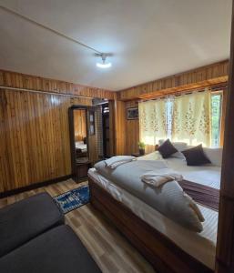 a bedroom with two beds and a couch in it at Zambalaas Inn in Darjeeling +31 photos