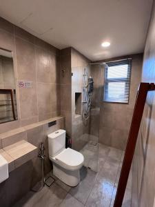 a bathroom with a toilet and a shower at Timurbay Seafront Kuantan Beach D'Sunset Ombak Samudera in Kuantan