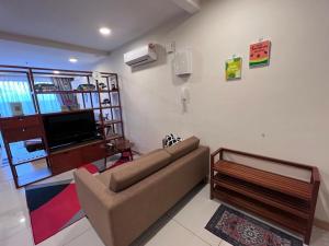 a living room with a couch and a flat screen tv at Timurbay Seafront Kuantan Beach D'Sunset Ombak Samudera in Kuantan +9 photos