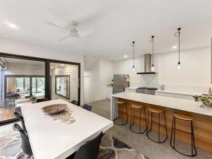 una cucina con bancone bianco e tavolo di Yellow Gum Retreat a Torquay