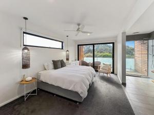 una camera da letto con un letto grande e una grande finestra di Yellow Gum Retreat a Torquay